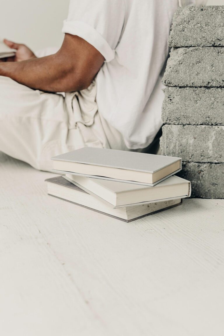 A person sitting on the ground with two books