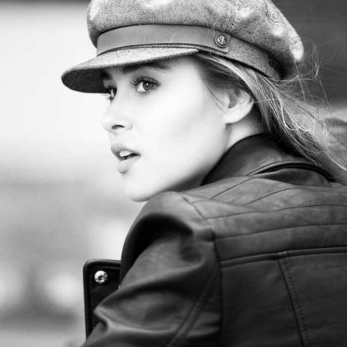 A woman wearing a hat and leather jacket.